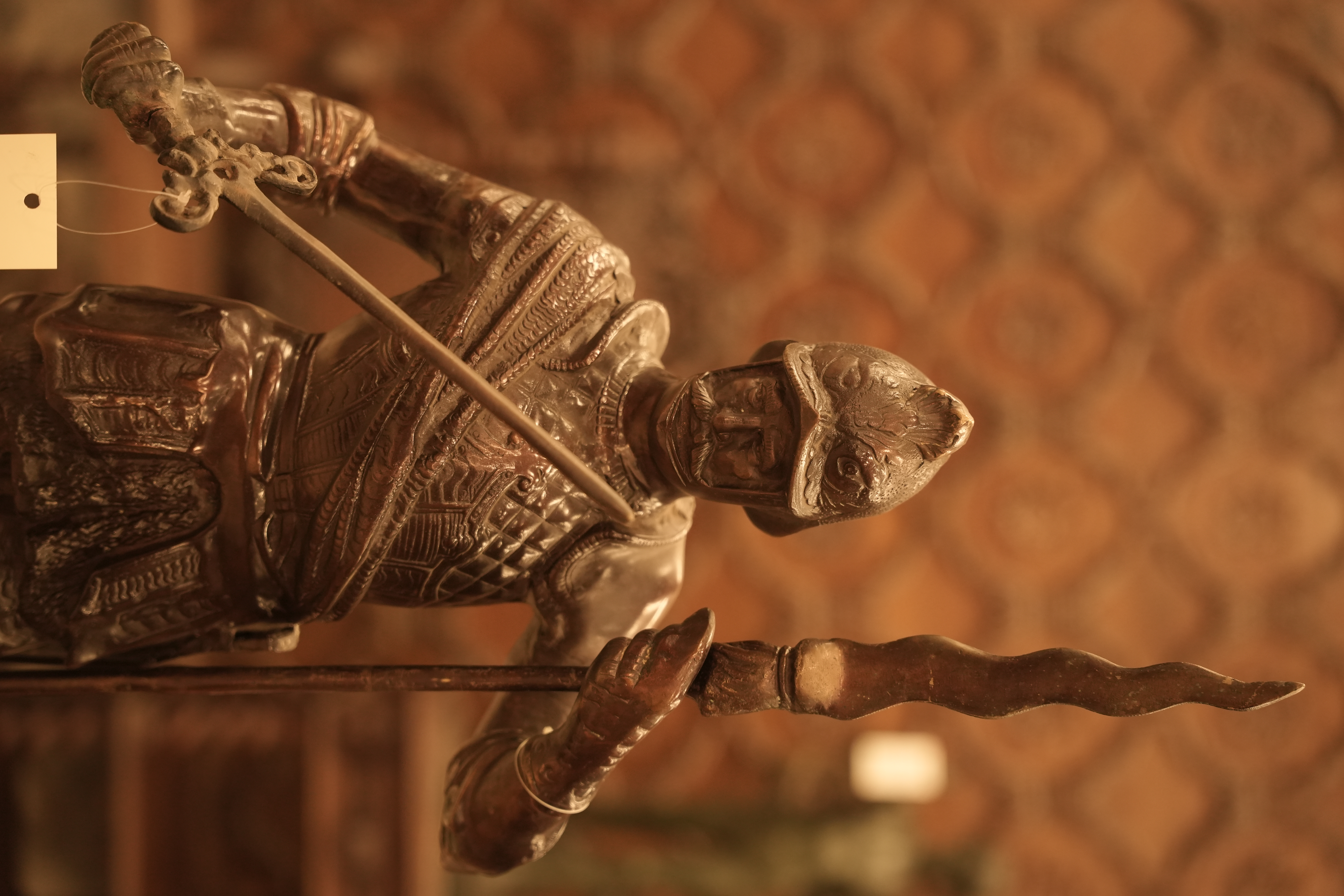 This is a large, bronze-finish brass statue depicting a 16th-17th century style soldier or Roman warrior holding a spear and sword.