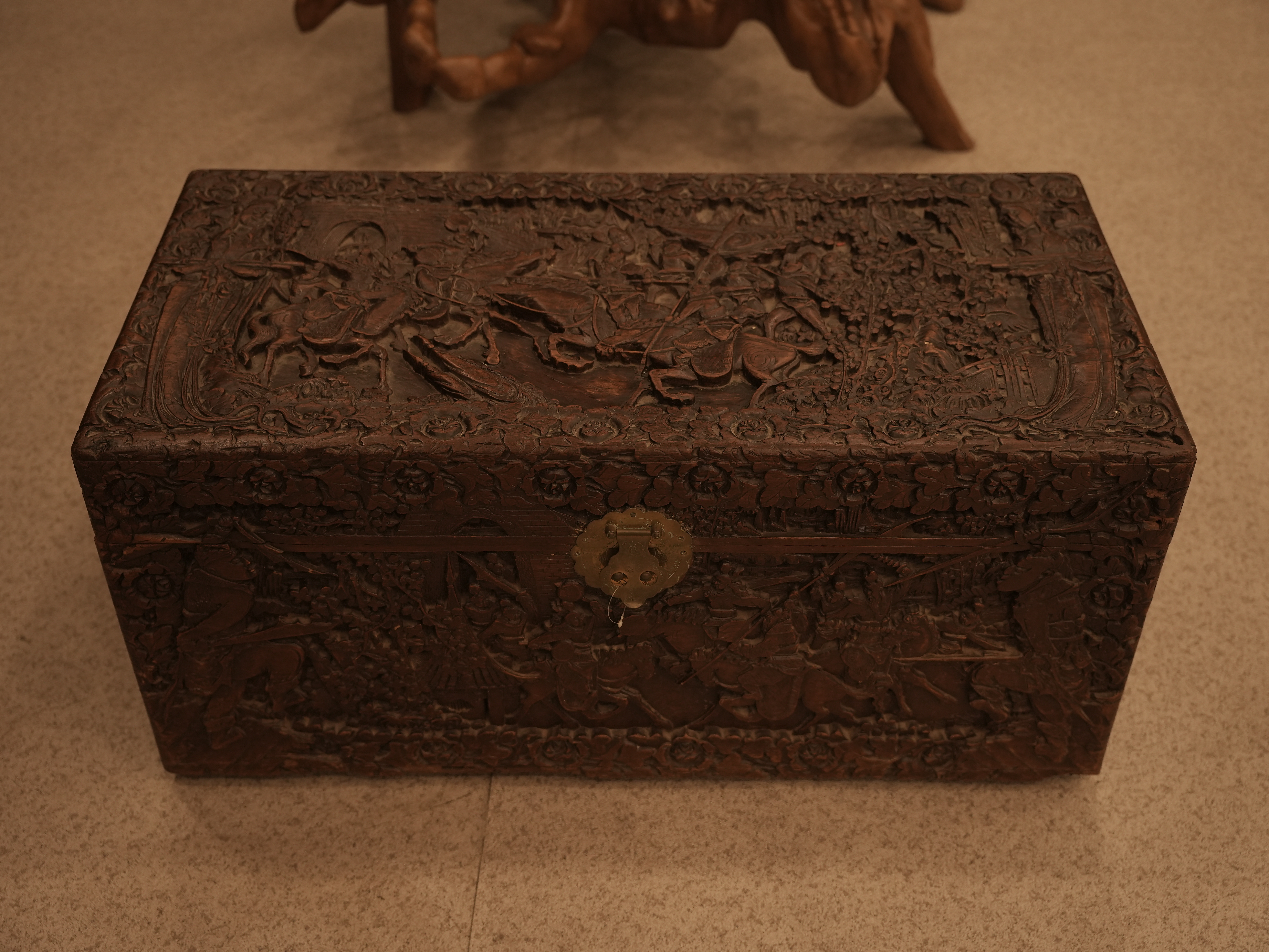 This heavily carved wooden chair with a cane seat is an antique European armchair with cane works, likely in the Renaissance Revival style.