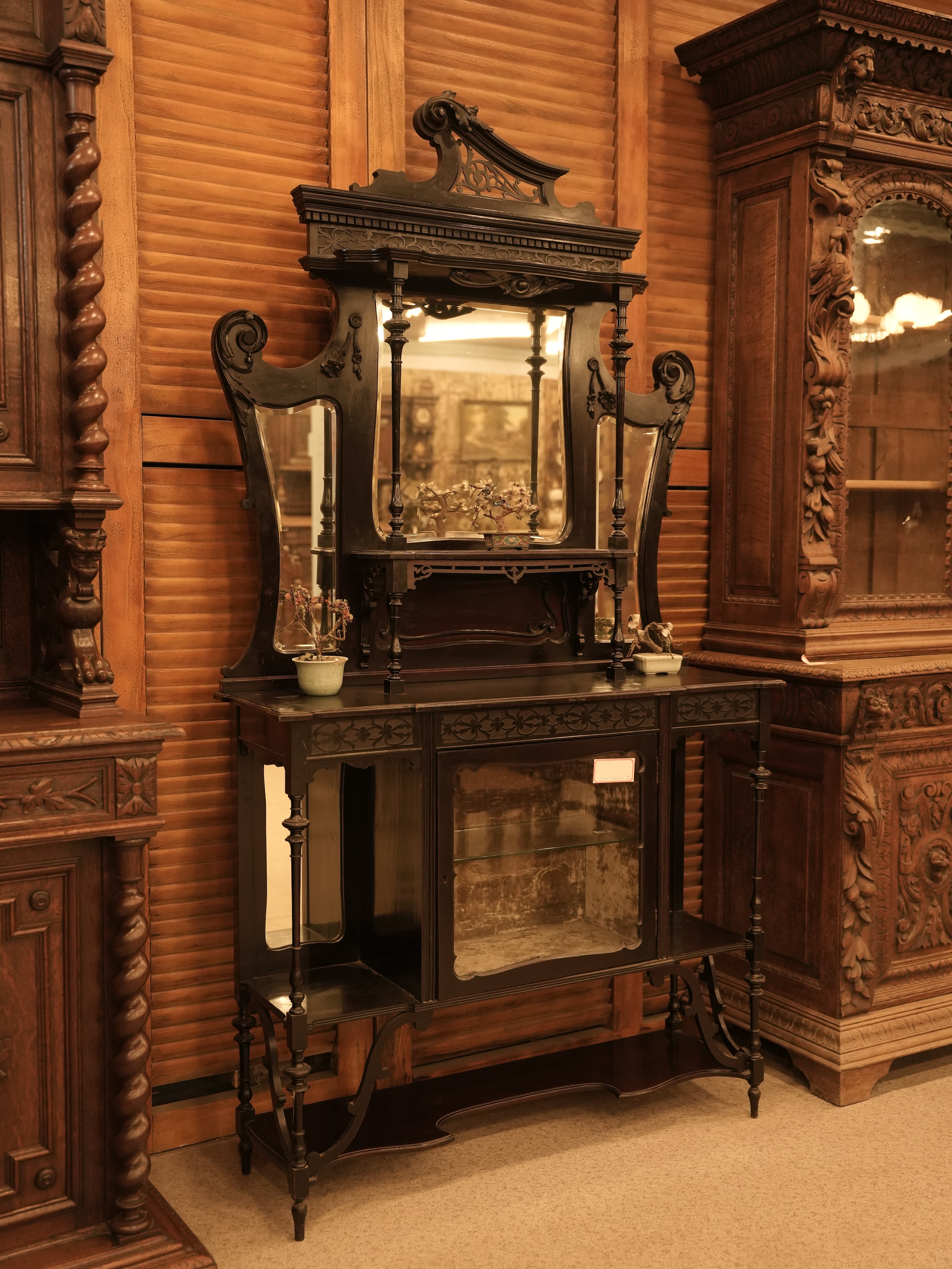 This is an antique Late Victorian English etagere display curio cabinet, likely made from carved mahogany.